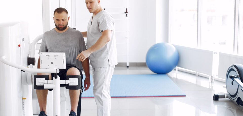 Doctor with a patient in physiotherapy clinic Patient has a rehabilitation in physiotherapy clinic. Doctor in a uniform.
