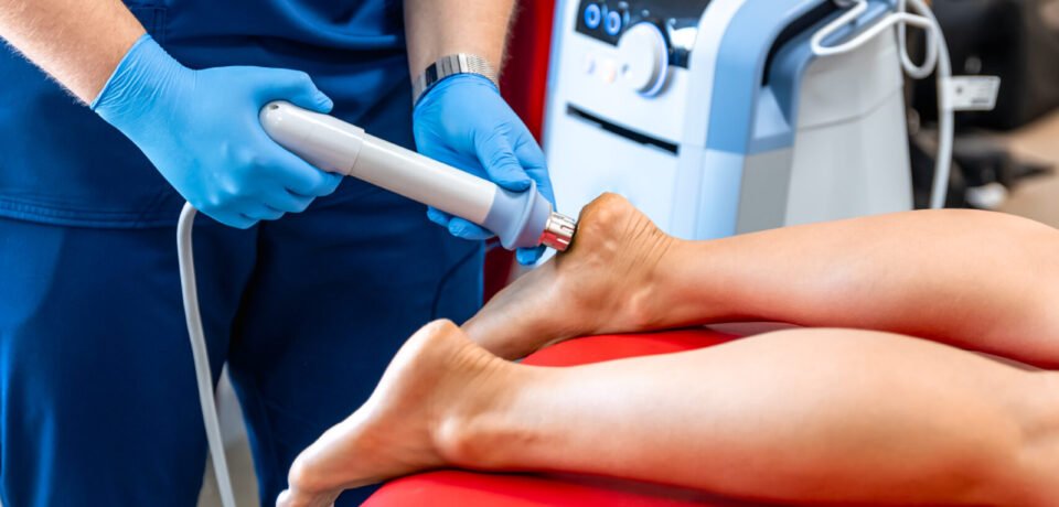 Shock wave therapy, the magnetic field, rehabilitation, physiotherapist doctor performs surgery on a patient's heel.