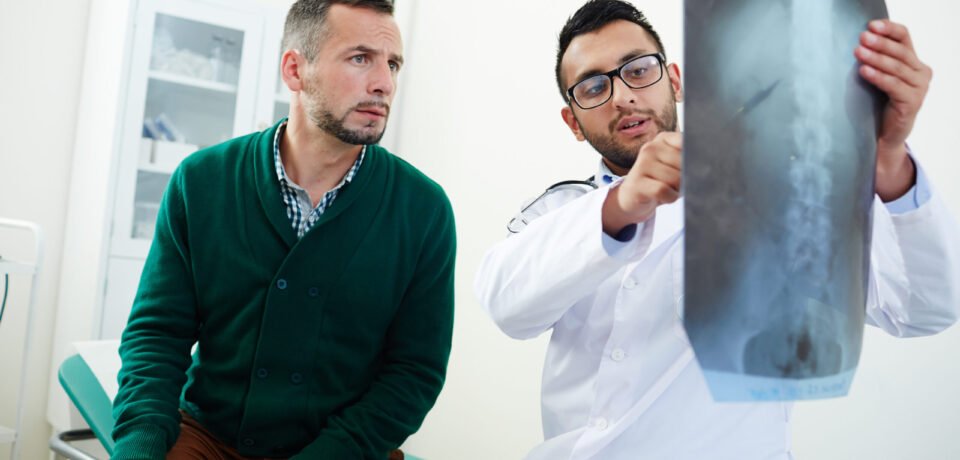 Visiting radiologist Radiologist with x-ray results explaining his patient problem with spinal cord